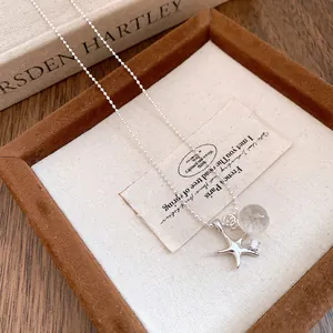 Dettaglio di una collana a stella marina in argento con perla in resina e strass.