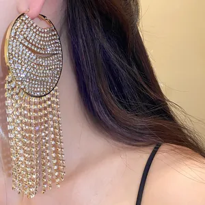 Macro view of gold-plated hoop earrings with sparkling rhinestone fringe and long tassels