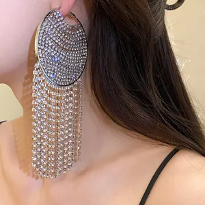 Close-up of elegant silver needle hoop earrings with rhinestone circle and long tassel