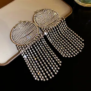 Detail shot of silver-toned rhinestone hoop earrings with shimmering long fringe tassels.