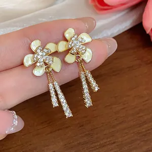 Detalle de los pendientes de flores bañados en oro de 18k con borlas de circonitas