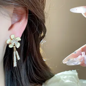Vista detallada de elegantes pendientes de flor de circón con baño de oro de 18k en la oreja