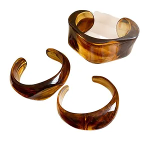 Bracciali rigidi aperti geometrici in acrilico marmorizzato, finitura resina ambra