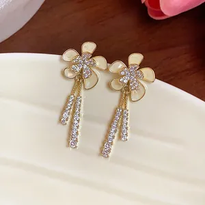 Primer plano de elegantes pendientes de flor con circonitas bañados en oro de 18k