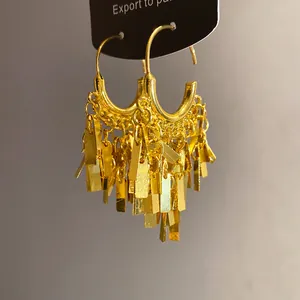 Detail view of gold geometric hoop earrings with layered rectangular metal tassels.