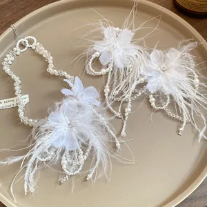 Dettaglio del set collana fiori piume bianche con eleganti perle vetro e design raffinato