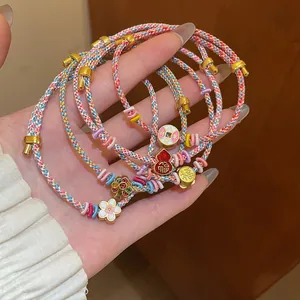 Detailed close-up of colorful hand-braided bracelets featuring flower and gourd charms