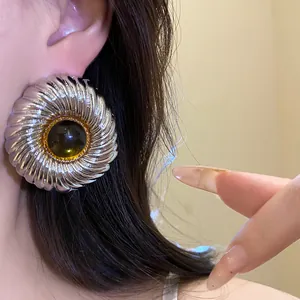 Close-up of vintage silver textured round earrings with dark amber resin center