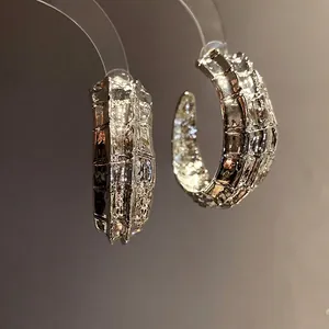 Pendientes de aro plateados en forma de C con un elegante acabado metálico texturizado