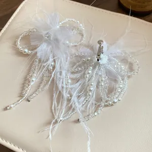 Vista dettagliata di eleganti accessori per orecchini a clip con piume e perle