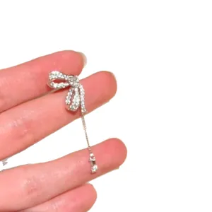Sparkling silver-tone zircon bow earrings featuring a delicate chain tassel drop.