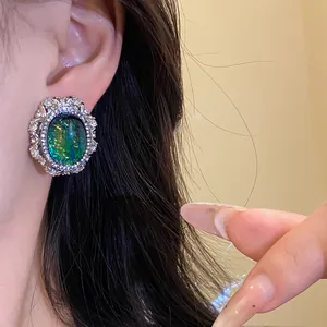 Dettaglio di orecchini vintage ovali in resina con perni in argento e diamanti