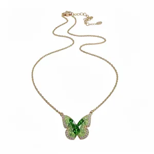 Elegant gold-tone necklace with a vibrant green crystal butterfly pendant and pavé zircon.