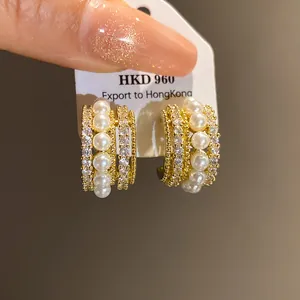 Nahaufnahme von Vintage-Goldohrringen mit Perlen und Zirkonia-Steinen im Detail