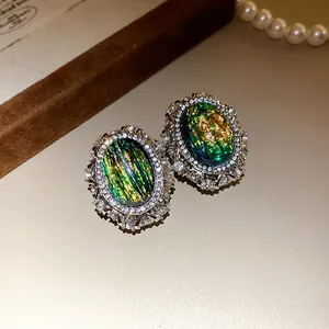 Dettaglio di orecchini vintage ovali in resina con alone di strass brillanti
