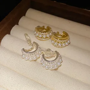 Detailansicht goldener und silberner C-Clip-Ohrringe mit Perlen und Zirkonia Steinen