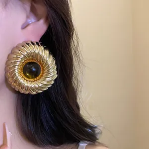Macro view of large vintage gold spiral ribbed resin stud earring for elegant style