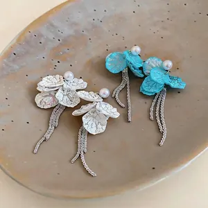 Elegant pearl stud earrings with textured flower petals and long silver tassel fringe
