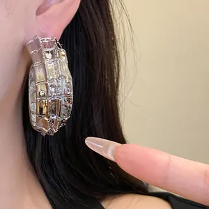Primer plano detallado de pendientes vintage plateados en forma de C con textura