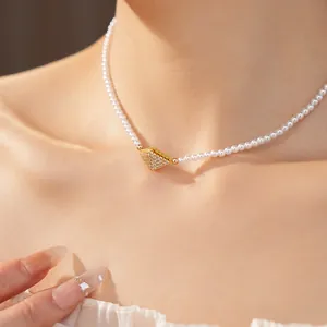 Detailed macro view of 18K gold plated zircon diamond pendant on a pearl necklace.