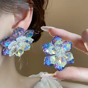 Gros plan de boucles d'oreilles fleurs en verre irisé avec facettes de cristal