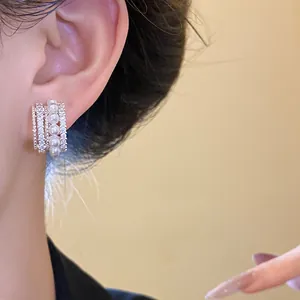 Nahaufnahme des 14k vergoldeten Ohrrings mit Zirkonia und eleganten Perlen.