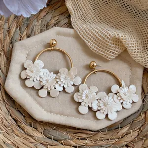 Vue détaillée de créoles de style français avec fleurs en cuir blanc et perles