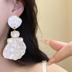 Large white pearlescent resin shell pendant earrings on model with French retro style