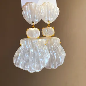 Macro detail view of elegant French vintage white resin shell drop earrings for women
