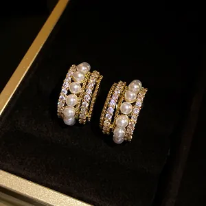 Nahaufnahme von 14k vergoldeten Ohrclips mit eleganten Perlen und funkelnden Zirkonia