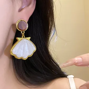 Elegant French vintage shell drop earrings with resin stud worn on ear close up view