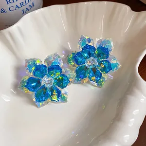 Macro d'élégantes boucles d'oreilles fleur en cristal bleu aux facettes étincelantes