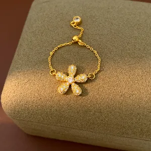 Close-up of gold-plated flower ring with sparkling zircon stones and adjustable chain.