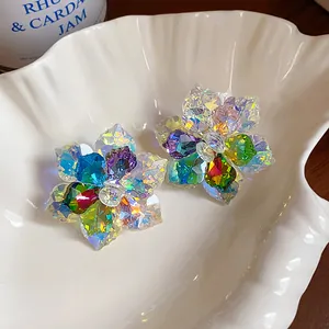 Gros plan sur des boucles d'oreilles fleurs en cristal coloré aux pétales facettés
