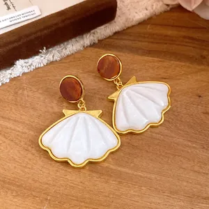 Close-up detail of vintage French style resin shell earrings with golden marbled studs