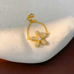 Exquisite detail view of a gold-plated flower chain ring with shimmering micro-pave crystals