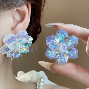 Vue détaillée des boucles d'oreilles fleurs en verre aurore irisé aux reflets multiples