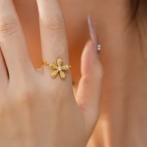Detailed macro view of an elegant gold flower ring set with shimmering clear crystals