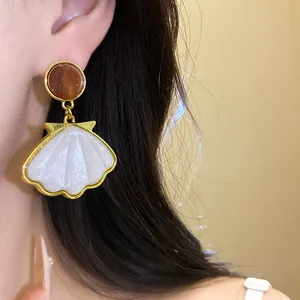 Detailed close-up showing a vintage resin shell drop earring worn on a model's ear
