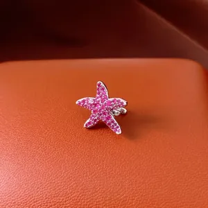 Sparkling pink zircon starfish non-piercing ear clip on orange textured leather.