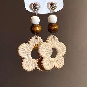 Elegant bohemian style resin flower drop earrings featuring wooden beads and silver needles.