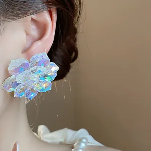 Vue détaillée d'une grande boucle d'oreille fleur en verre iridescent sur un modèle.