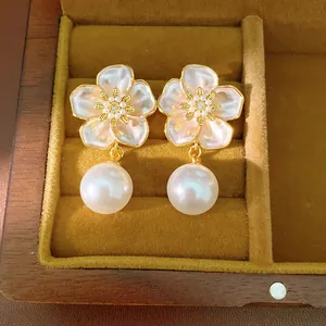 Vue détaillée de boucles d'oreilles fleur avec pétales en émail et zircon