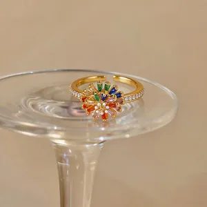 Detailed close-up of an 18k gold plated open ring with a vibrant zircon flower design.