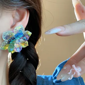 Gros plan de boucles d'oreilles fleurs en verre coloré portées par un mannequin de style