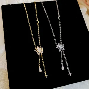 Detailed view of gold and silver star necklaces with sparkling zircon drops on black velvet