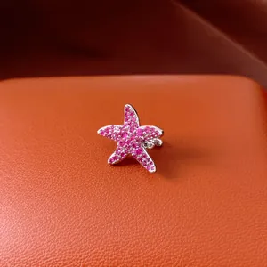 Close-up of elegant starfish ear cuff with sparkling pink zircon pavé setting on leather