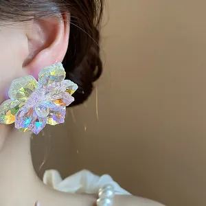 Gros plan détaillé de boucles d'oreilles fleur en verre irisé aux reflets colorés