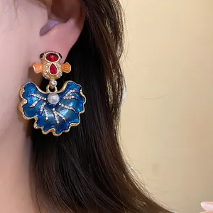 Macro view of blue enamel vintage earrings with rhinestones and pearl decorations.