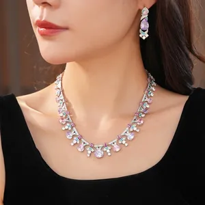Palace style necklace and earring set with pink and purple zircon stones on a model